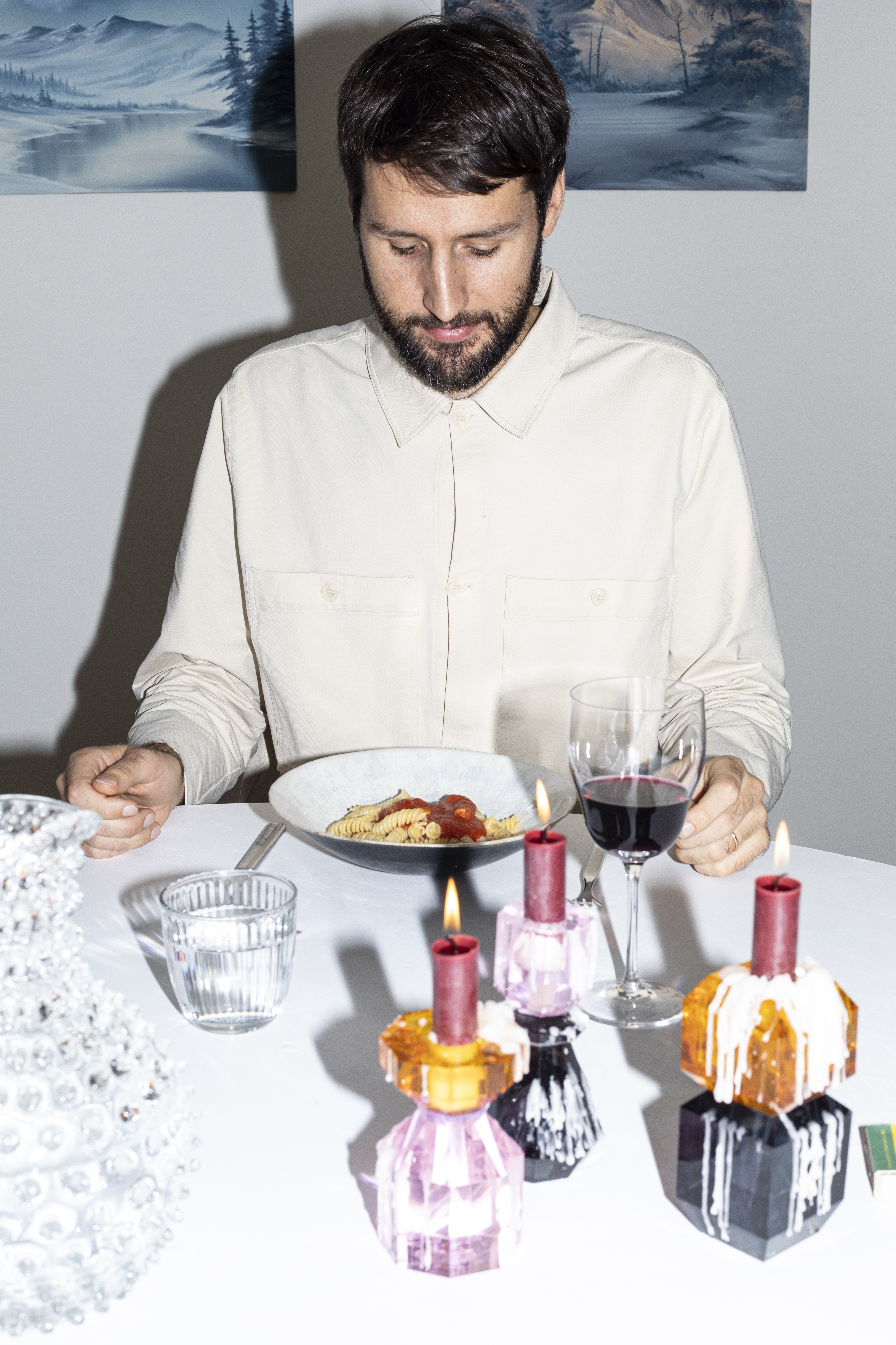 David Glanzmann vor einem Teller Tomatenpasta bei Kerzenschein und einem Glas Wein.